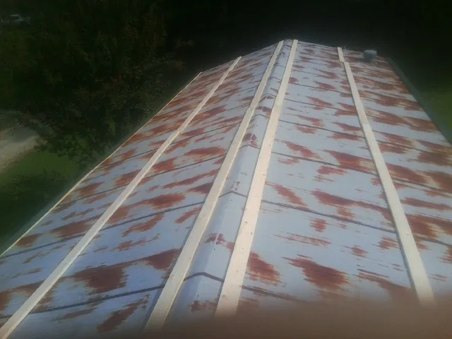 Rusted metal roof panels with new wood purlins before replacement — Storm Damage Roof Repair in Mcloud by Roofing Brothers