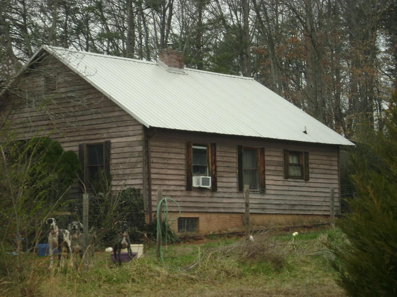 White metal roof on an old wood sided farmhouse, from a Metal Roof Installation job in Mcloud